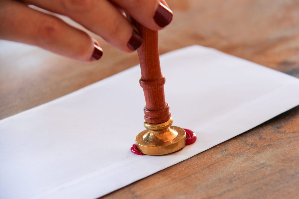 rituel-ceremonie-laique-cire-001 Focus sur une main d'un couple heureux lors d'une cérémonie laïque, à Toulouse en Occitanie lors du rituel du cachet de cire et de la lettre d'amour scellée