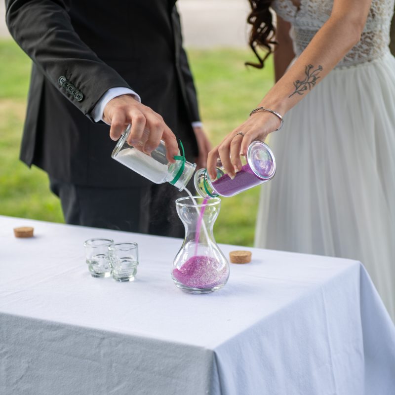 Focus sur les mains d'un couple heureux lors d'une cérémonie laïque, à Toulouse en Occitanie lors du rituel du sable